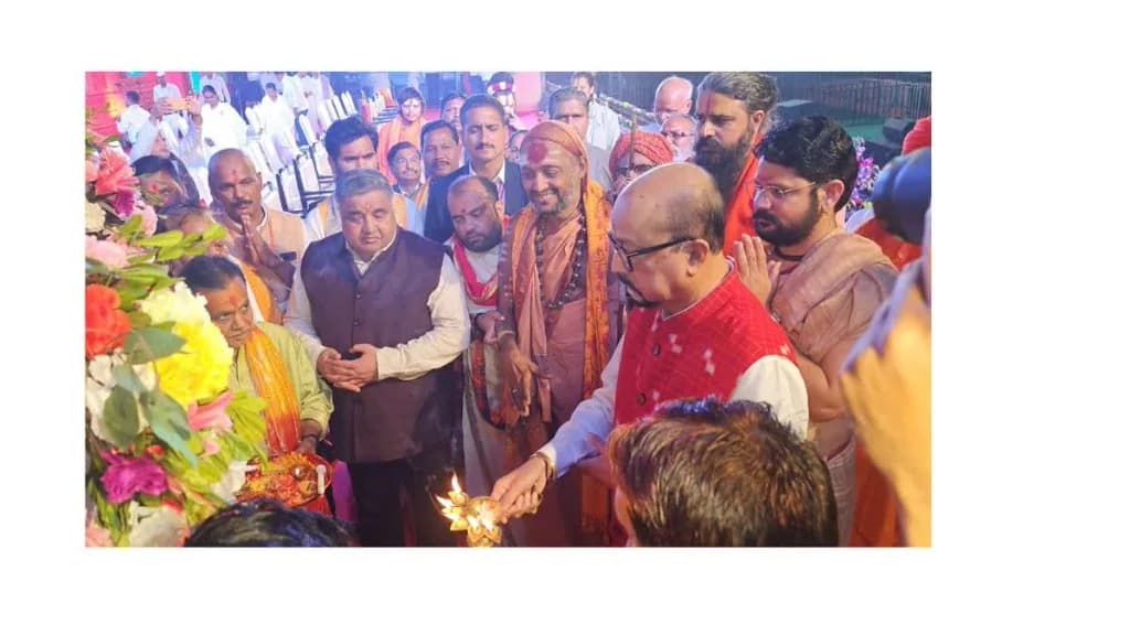 Rajesh Agrawal, in a dark vest, with saints at a lamp during Rajim Kumbh Kalp